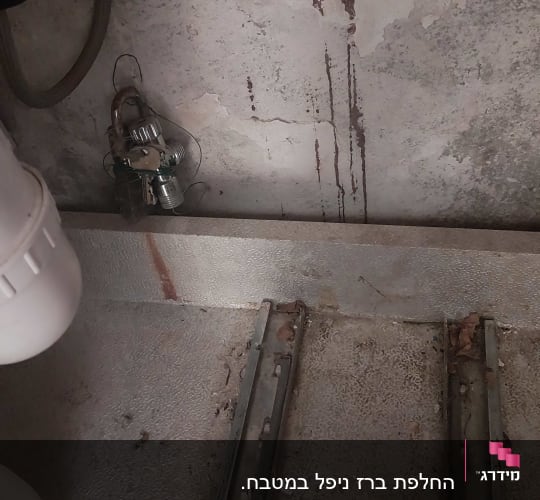 צינורות וכלים מתכתיים על קיר בטון ישן